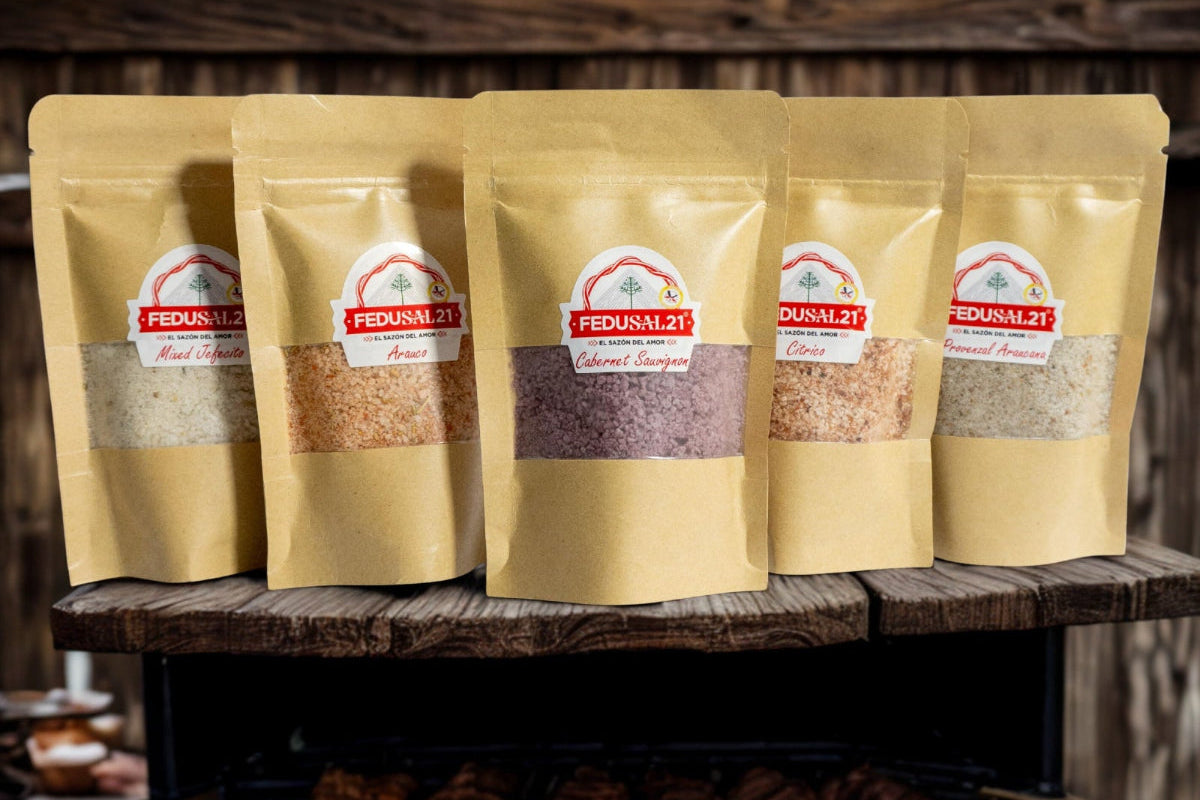 Five packages of Fedusal21 seasoning on a wooden stand with grilled meats below.